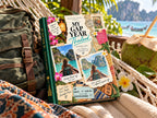 Adventure travel photo book on a beach hammock with a backpack and a fresh coconut